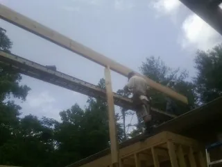 Carpenter setting a ridge beam over a new addition frame — Ice Dam Removal by Roofing Brothers in Rowland Heights