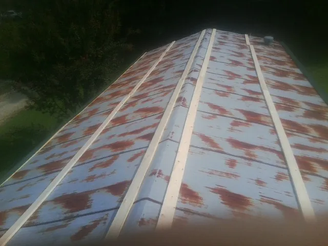 Rusted metal roof panels with new wood purlins before replacement — Storm Damage Roof Repair in Rowland Heights by Roofing Brothers