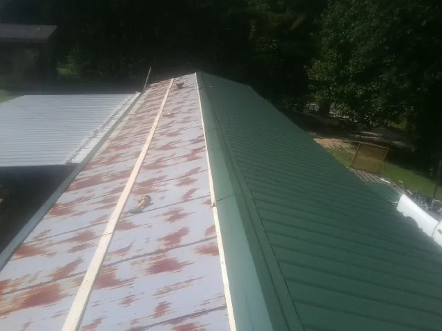 Old rusted panels beside newly installed green metal roofing — Wind Damage Roof Repair by Roofing Brothers in Rowland Heights