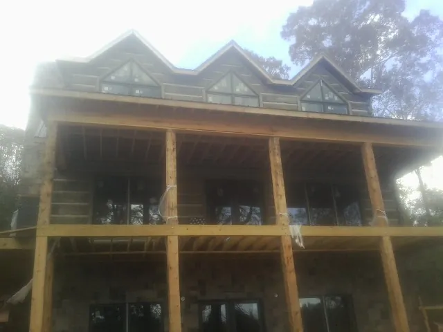 Dormers and porch framing on a large log home under construction — Roof Coating work by our crew in Rowland Heights