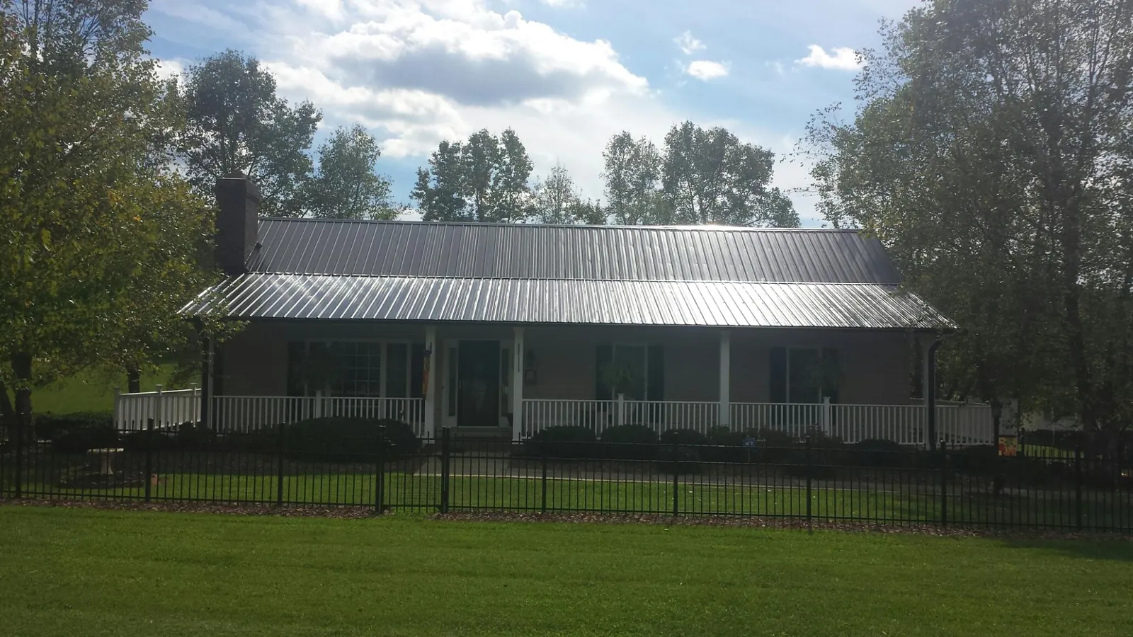 Gray metal roof on a brick ranch with a full width front porch — Gutter Guard Installation work by our crew in Rowland Heights