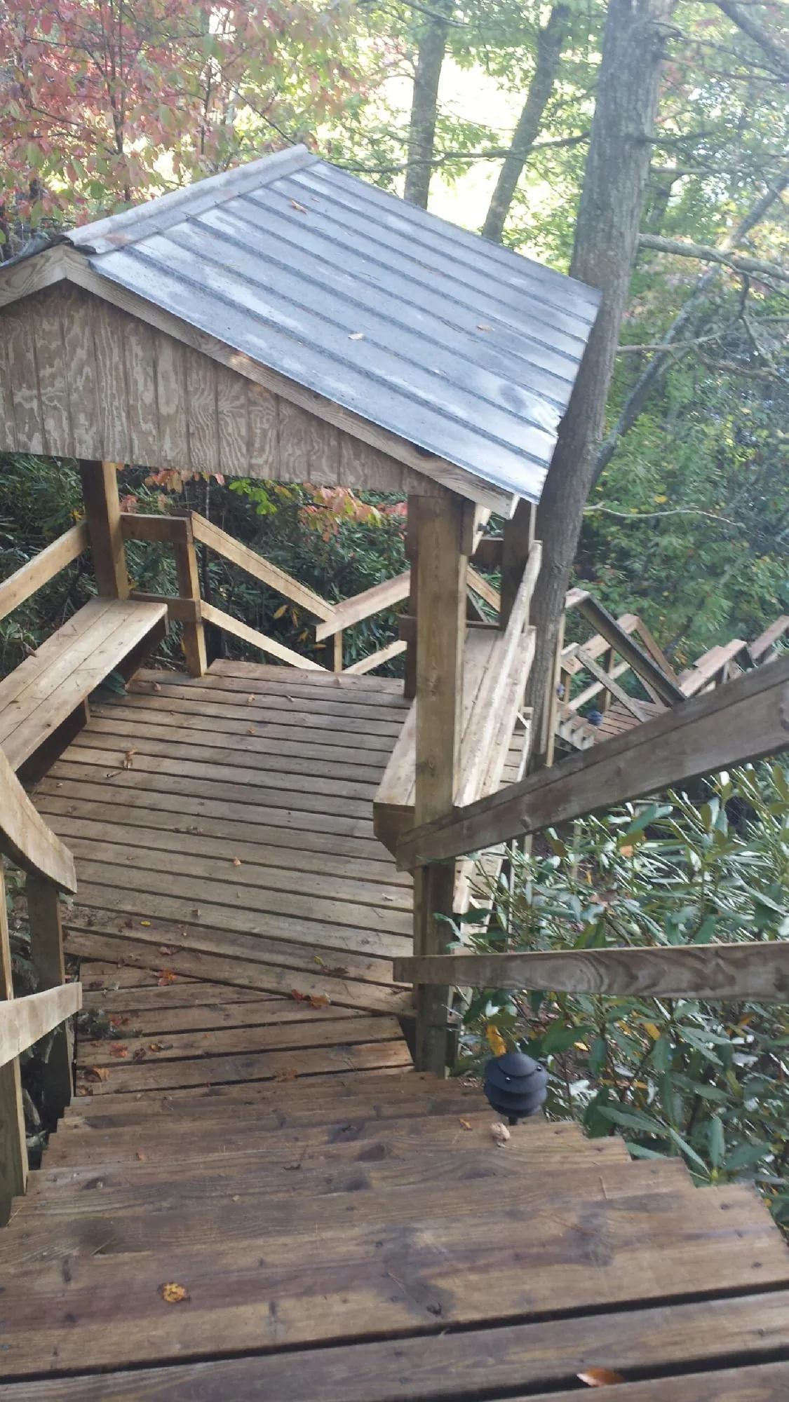 Metal roofed shelter over wooden steps on a wooded walkway — Skylight Repair & Installation work by our crew in Rowland Heights