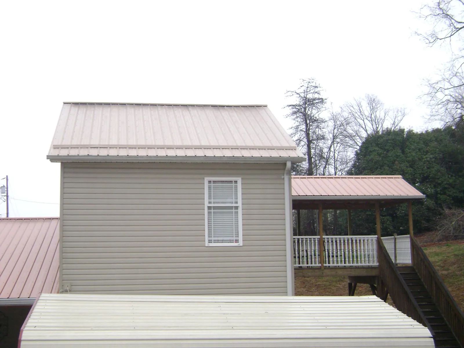 Tan metal roofs on a two story addition and attached porch, from a Roof Replacement job in Rowland Heights